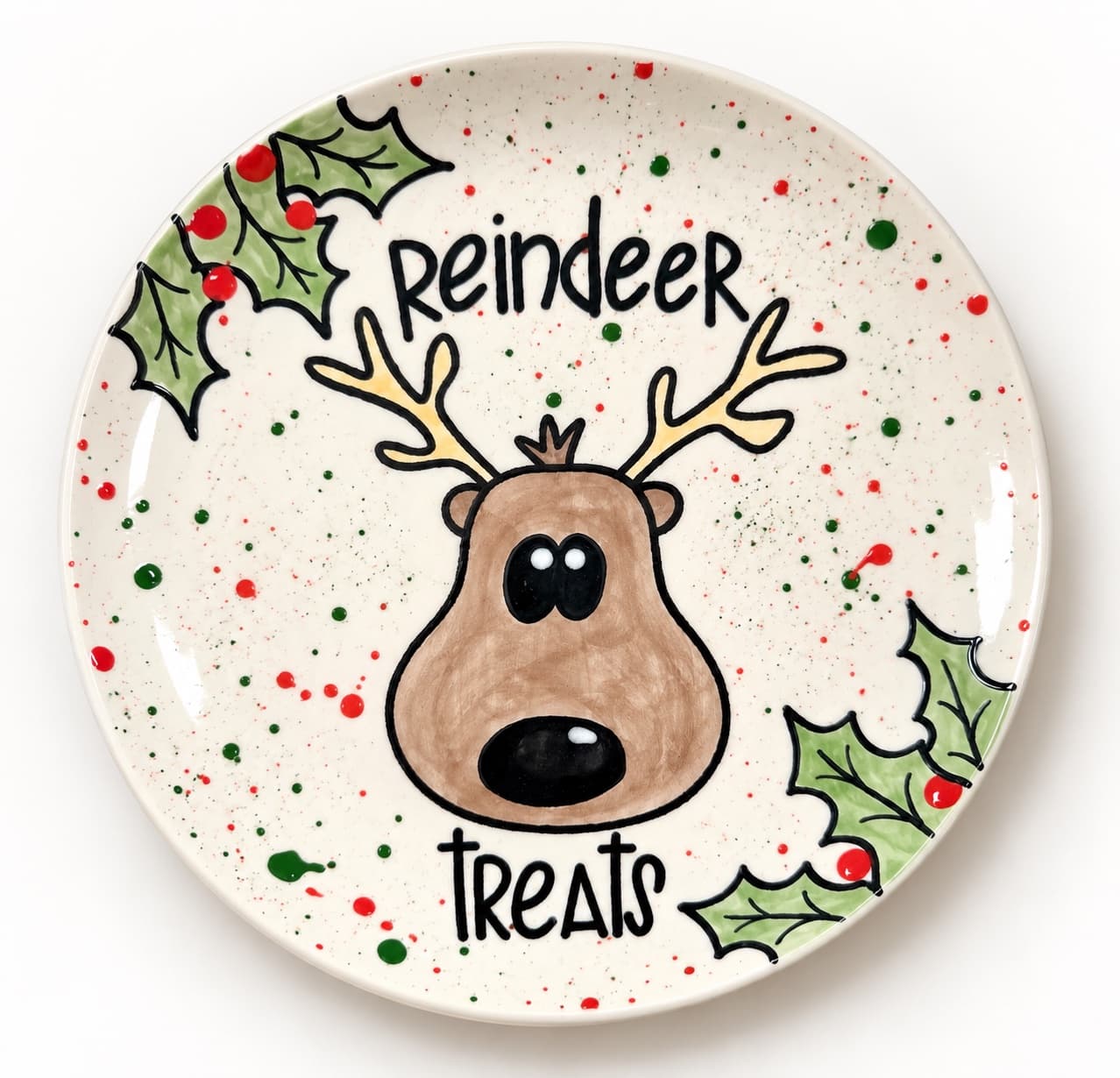 A hand-painted Reindeer Treats plate with a cartoon reindeer face, holly leaves and red and green splatter